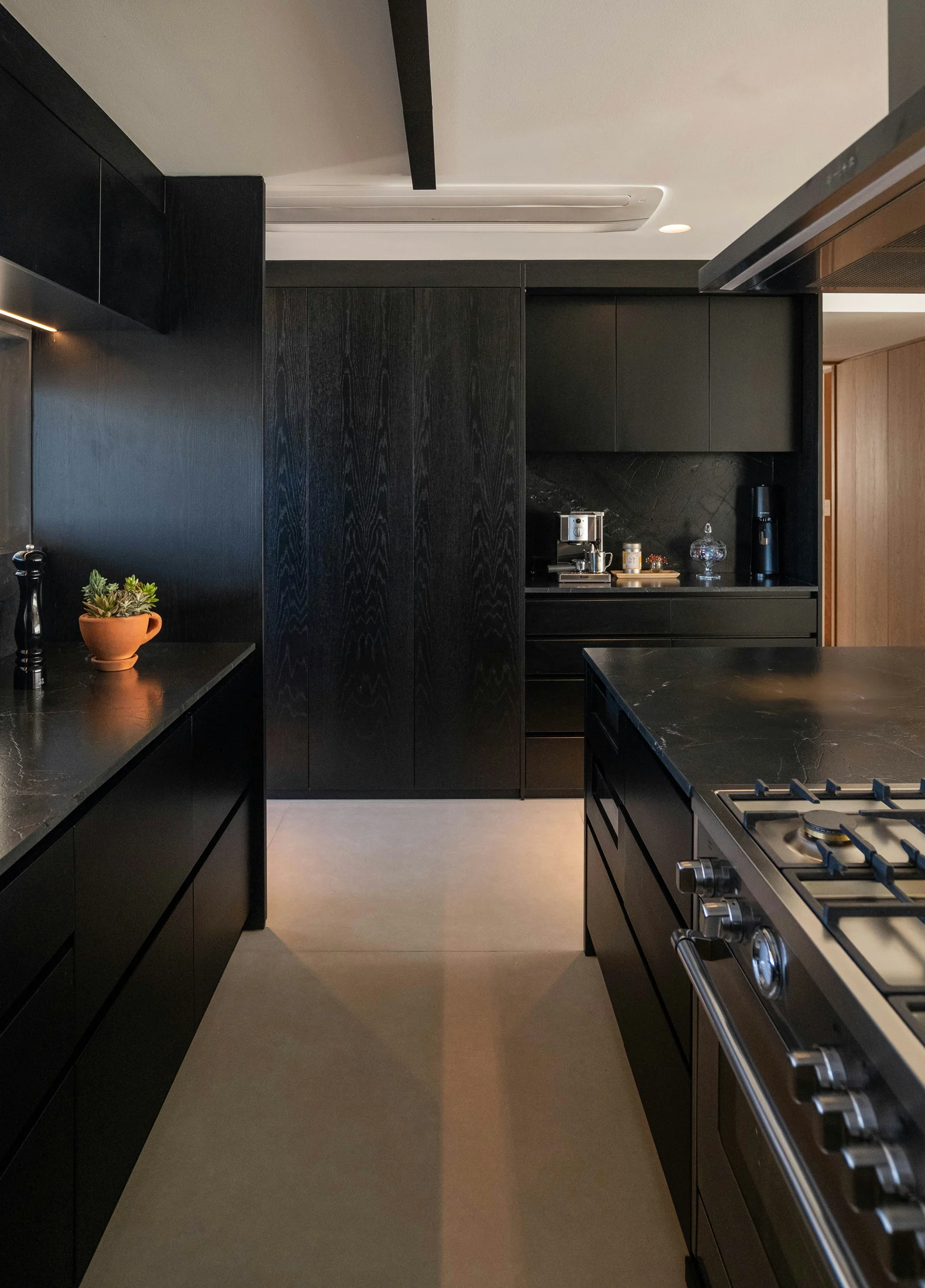 A black oak kitchen with dark marble counters